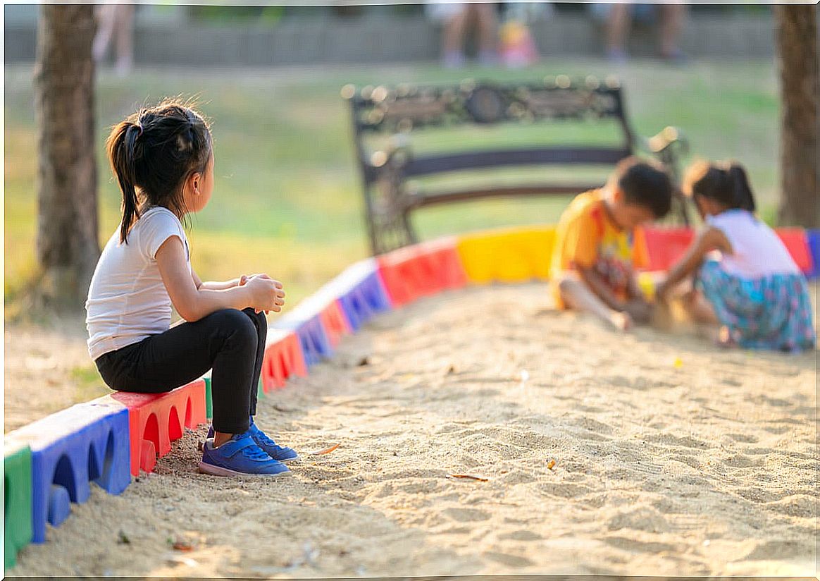 Little girl watching as other children play