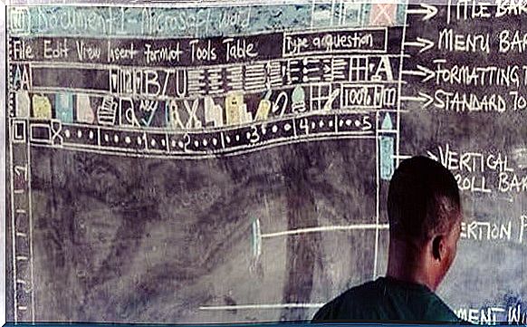 Ghanaian teacher giving class on a blackboard