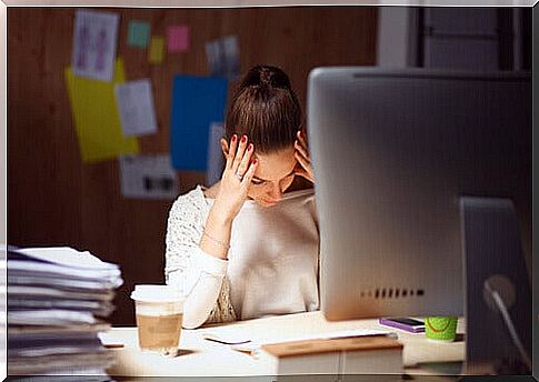 Young woman with burnout in front of her desk