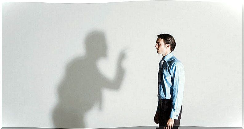 Man looking at his shadow while criticizing him