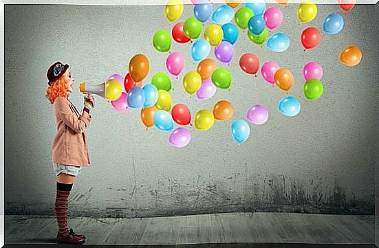 clown woman with megaphone from which balloons come out making a fool of herself