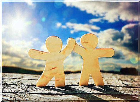 Two dolls shaking hands as a symbol of friendship