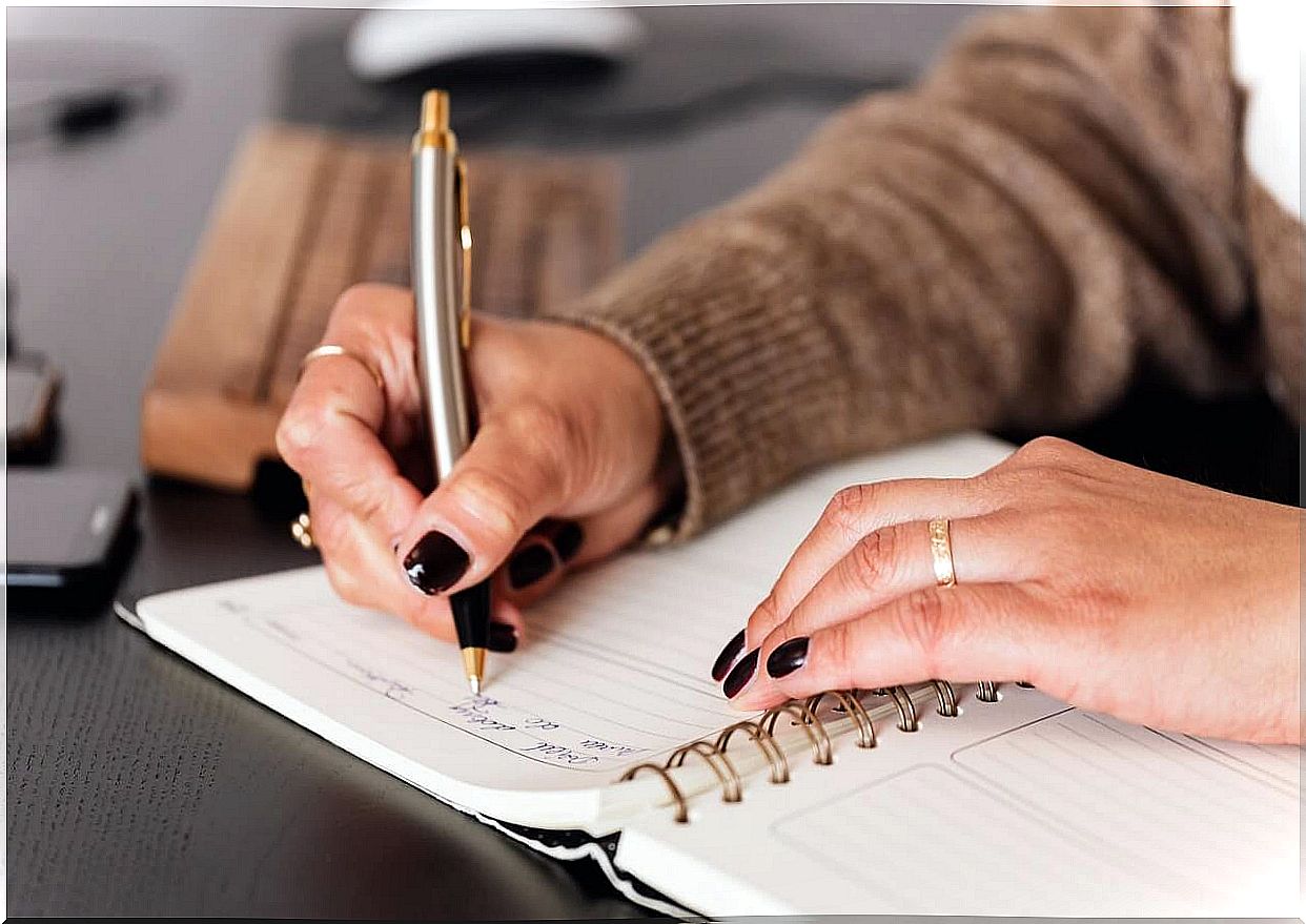 Woman writing down her personal growth plan in a notebook.