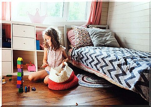 Little girl picking up toys