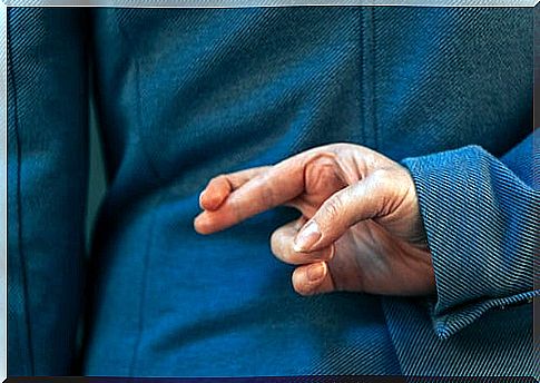 Woman crossing fingers when lying to represent blue lies