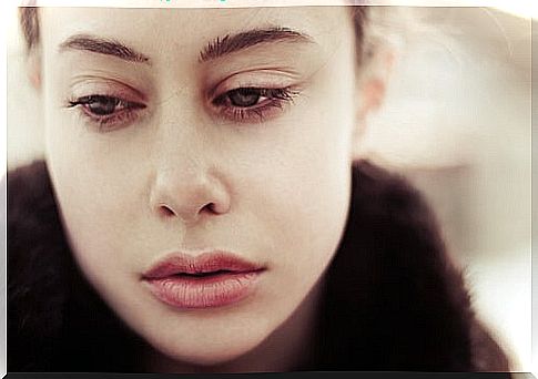 Woman looking down sadly at a traumatic memory