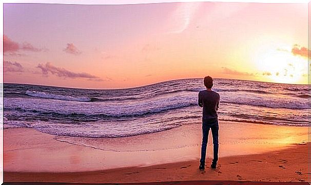 lonely boy looking at the beach at sunrise thinking about the phases of stress