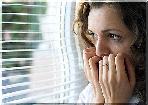 Woman in anguish looking out of a window