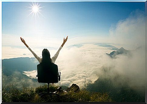 Woman sitting with hands up celebrating her success